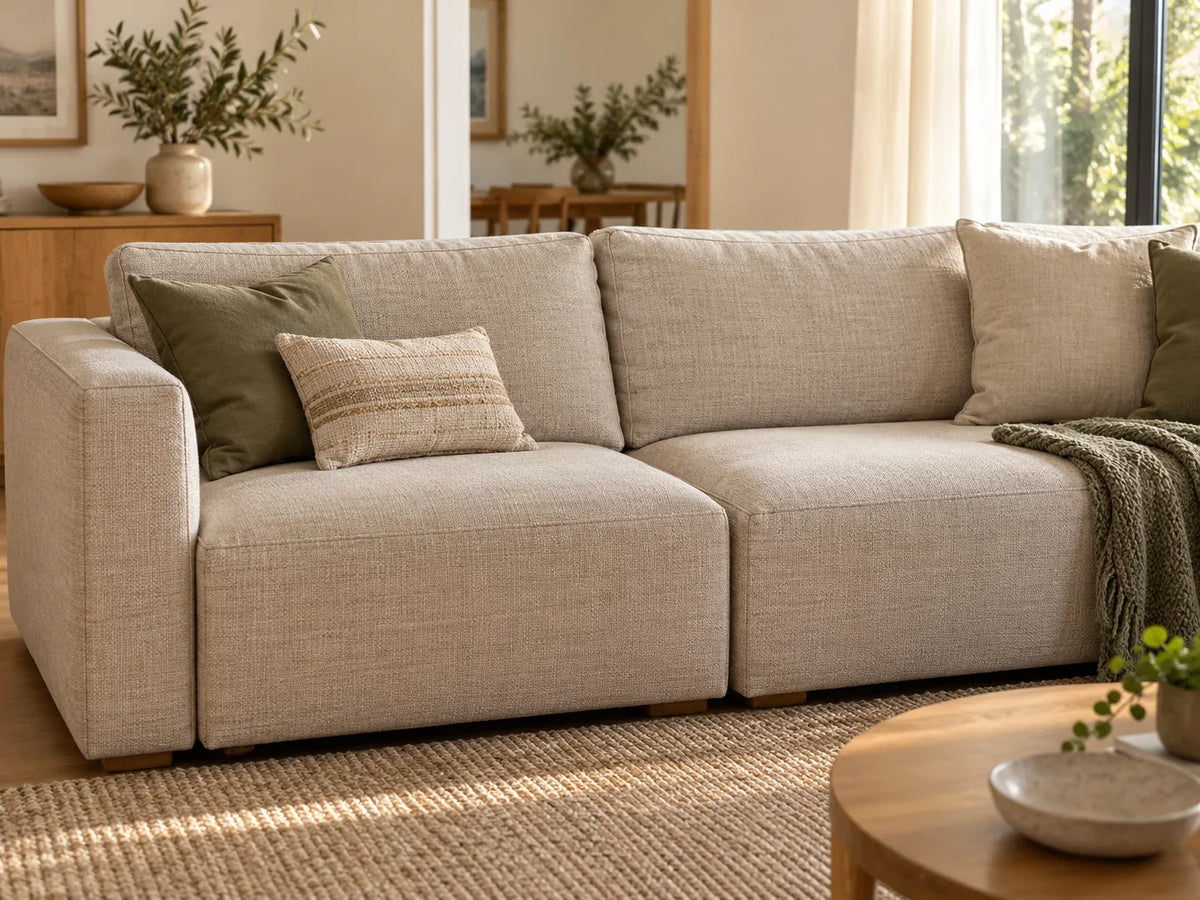 A neutral modular sofa with a visible join between two seat sections in a softly lit lounge.