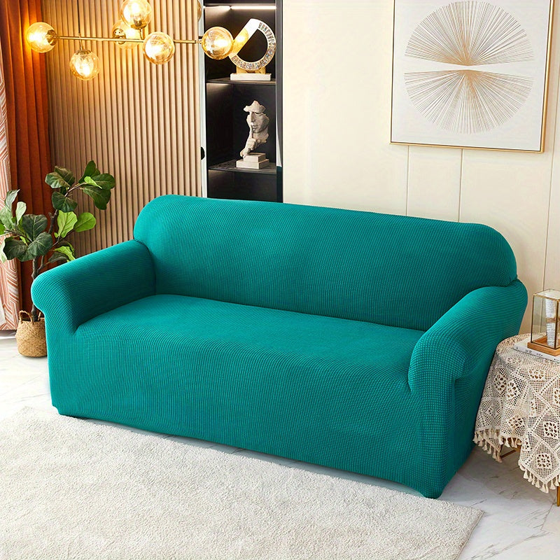 Calma cover in the option labelled Olive Green, shown in blue-green; wide view over the seat and arms