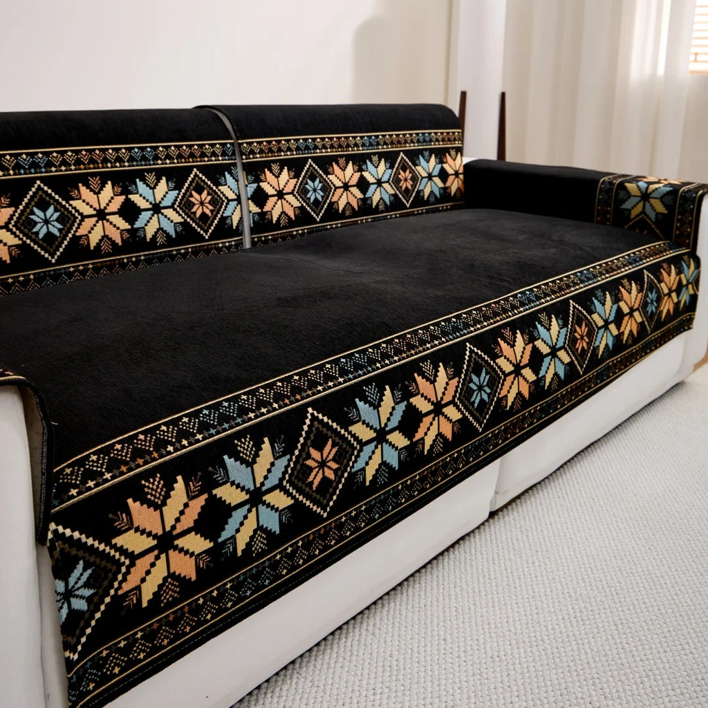 Black Sorrento cover pieces with multicoloured geometric borders across a white sofa