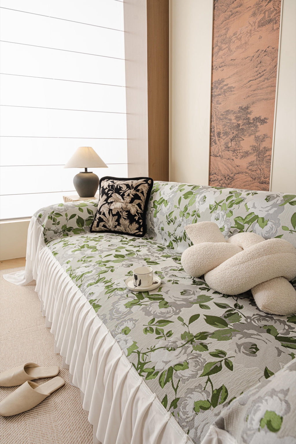 Camellia pale floral sofa throw with green leaves and a gathered white skirt.